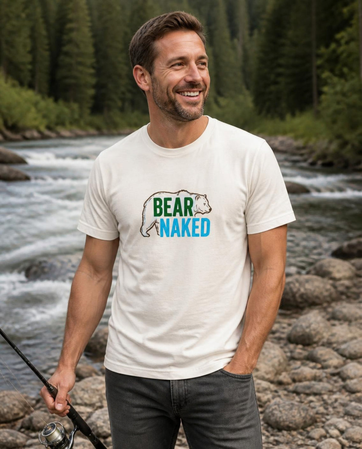 Man wearing a vintage white Bear Naked t-shirt on a riverbank in the BC wilderness