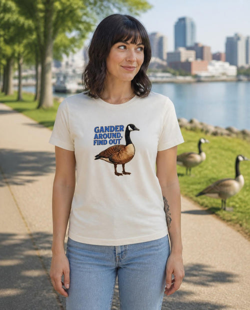 Woman wearing a vintage white Gander Around Find Out t-shirt in a waterfront park with Canada geese