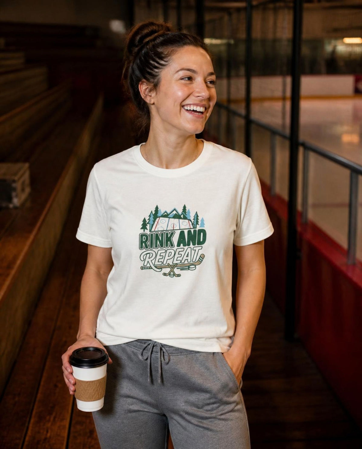 Woman wearing a vintage white Rink and Repeat t-shirt in a hockey arena