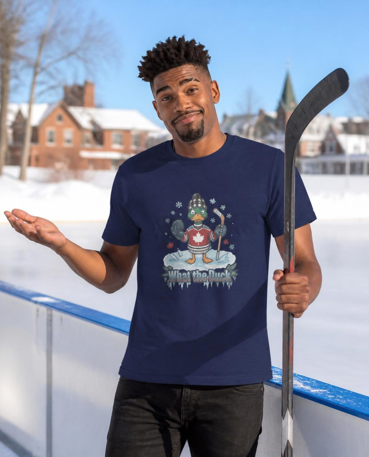 Man wearing a navy What the Duck? hockey t-shirt at an outdoor ice rink